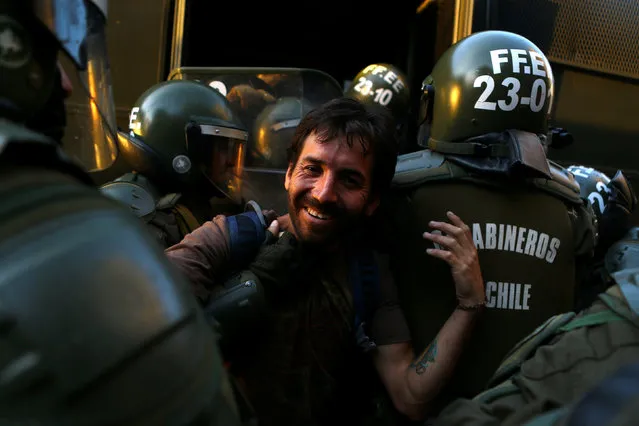 A demonstrator is detained during a rally marking the anniversary of the death of workers union leader Juan Pablo Jimenez, in Santiago, Chile February 21, 2017. (Photo by Ivan Alvarado/Reuters)