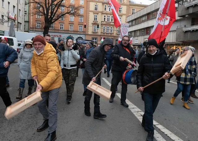 Protesters take part in a demonstration against the Austrian government's measures taken in order to limit the spread of the coronavirus, on December 12, 2021 in Innsbruck, Austria, amidst the novel coronavirus / Covid-19 pandemic. The Innsbruck demonstration is only one in a string of huge weekend protests since Austria in November 2021 became the first EU country to say it would make Covid vaccinations mandatory. (Photo by Daniel Liebl/APA/AFP Photo)