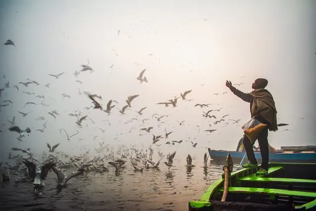 People arrive early in the morning on the bank of Yamuna River to see the migratory seagulls which comes from Siberia in winters on the first day of the 2022 year amid dense fog as Delhi plunged to minimum temperature dips to 4 degrees Celsius on the first day of New Year. (Photo by Mohsin Javed/Pacific Press/Rex Features/Shutterstock)