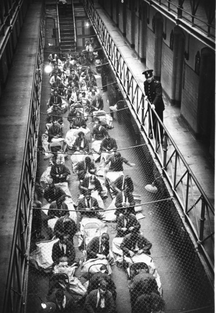 A prison officer watches over prisoners who are busy sewing mailbags in Strangeways Prison, Manchester, UK, 20th November 1948. (Photo by Bert Hardy/Picture Post/Getty Images)