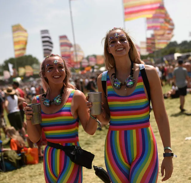 Festival-goers enjoy the fine weather on the third day of the Glastonbury Festival of Music and Performing Arts on Worthy Farm near the village of Pilton in Somerset, South West England, on June 28, 2019. (Photo by Oli Scarff/AFP Photo)
