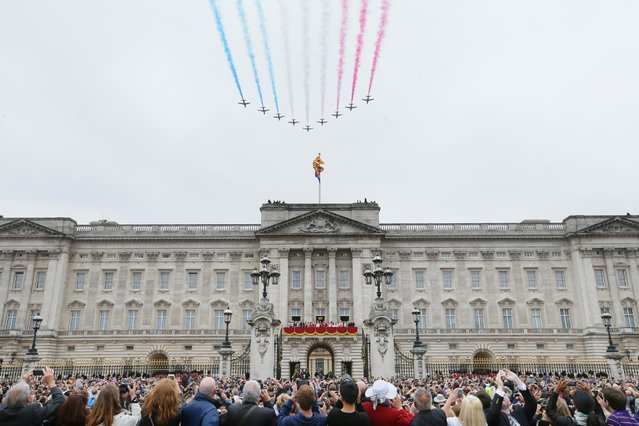 The Red Arrows make a flypast during the Trooping The Colour parade at Buckingham Palace, in London, Saturday, June 13, 2015. Hundreds of soldiers in ceremonial dress have marched in London in the annual Trooping the Color parade to mark the official birthday of Queen Elizabeth II. The Trooping the Color tradition originates from preparations for battle, when flags were carried or "trooped" down the rank for soldiers to see. (AP Photo/Tim Ireland)
