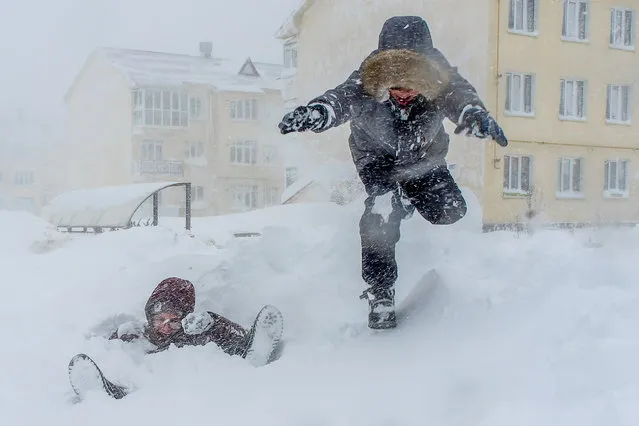 Children play during a heavy snowstorm on Sakhalin Island in Yuzhno-Sakhalinsk, Russia on January 13, 2022. Weather reports indicate the year’s first snowstorm has brought 44mm of snow, which is close to the monthly average for January. (Photo by Sergei Krasnoukhov/TASS)