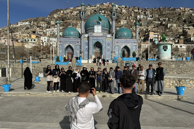 In this picture taken on March 25, 2024 Thai tourists pose for a group picture during their visit to the Kart-e-Sakhi Shrine in Kabul. Decades of conflict made tourism extremely rare, and while most violence has now abated visitors are confronted with extreme poverty, dilapidated cultural sites and scant hospitality infrastructure. (Photo by Wakil Kohsar/AFP Photo)