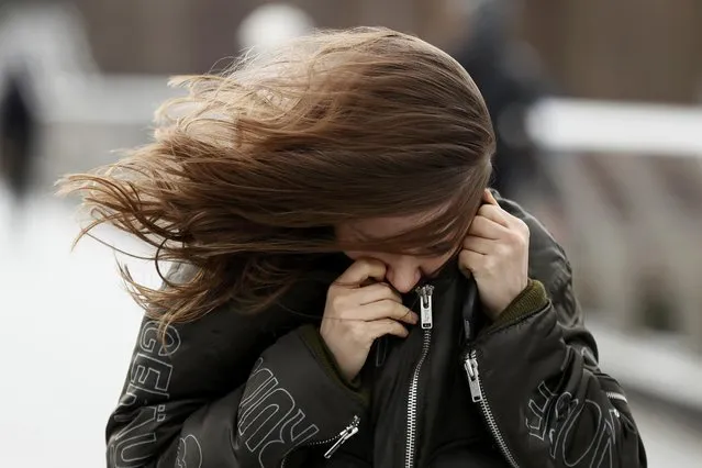 A pedestrian has her hair blown as she walks across a bridge during strong winds in London, Britain, February 23, 2017. (Photo by Stefan Wermuth/Reuters)