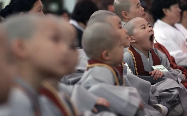 A shaven-headed boy yawns during a lighting ceremony to celebrate Buddha's upcoming birthday on May 14 at the Jogye Temple in Seoul, South Korea, Wednesday, May 4, 2016. Ten children entered the temple to have an experience of monks' life for two weeks. (Photo by Ahn Young-joon/AP Photo)