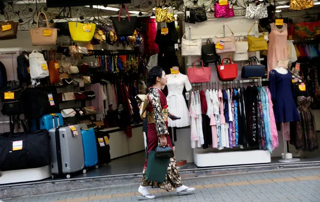 A woman in a kimono walks past a shop in a shopping district in Tokyo, Japan March 23, 2017. (Photo by Kim Kyung-Hoon/Reuters)