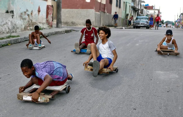 Children play with their “chivichanas”, hand-made trolleys they races with, at a street of Havana, Cuba, 19 June 2019. Children in Havana are on school holidays. (Photo by Yander Zamora/EPA/EFE)