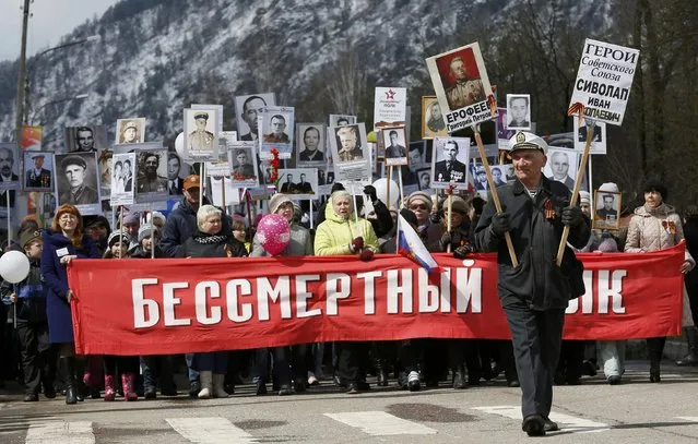 People carry pictures of World War Two participants as they take part in the Immortal Regiment march during the Victory Day celebrations, marking the 71st anniversary of the victory over Nazi Germany in World War Two, in the town of Divnogorsk near Krasnoyarsk, Siberia, Russia, May 9, 2016. (Photo by Ilya Naymushin/Reuters)