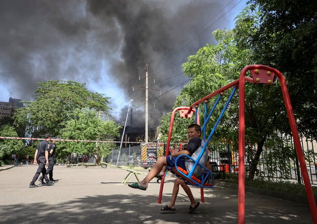 A boy swings near a site of a Russian missile strike, amid Russia's attack on Ukraine, in Odesa, Ukraine on June 24, 2024. (Photo by Reuters/Stringer)