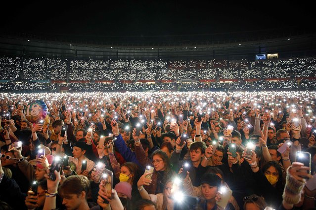 Participants with the lights of their smartphones illuminate the Ernst Happel Stadium in Vienna on March 19, 2022, during the charity concert “We Stand With Ukraine”. More than 3.3 million refugees have now fled Ukraine since the Russian invasion, the United Nations said on March 19, 2022, while nearly 6.5 million are thought to be internally displaced within the country. (Photo by Florian Wieser/APA via AFP Photo)