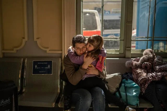 A Ukrainian evacuee hugs a child in the train station in Przemysl, near the Polish-Ukrainian border, on March 22, 2022, following Russia's military invasion launched on Ukraine. The UN says almost 3,6 million people have fled Ukraine since the Russian invasion, with more than two million of them heading to neighbouring Poland. (Photo by Angelos Tzortzinis/AFP Photo)