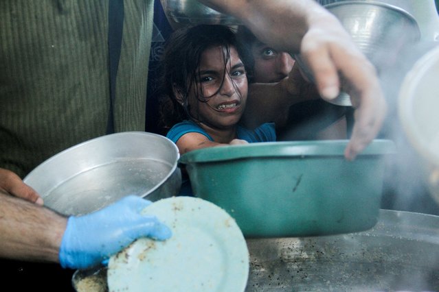 Palestinian children gather to receive food cooked by a charity kitchen, amid food scarcity, as Israel-Hamas conflict continues, in the northern Gaza Strip, on July 18, 2024. (Photo by Mahmoud Issa/Reuters)