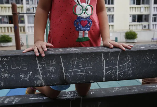 In this Tuesday, July 7, 2015 photo, a girl climbs on a bar marked with noughts and crosses (tic-tac-toe) at a park in Hong Kong. (Photo by Kin Cheung/AP Photo)