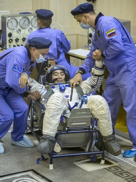 Kimiya Yui of Japan, a member of the International Space Station crew, is assisted during a space suit check at the Baikonur cosmodrome, Kazakhstan, July 22, 2015. (Photo by Shamil Zhumatov/Reuters)