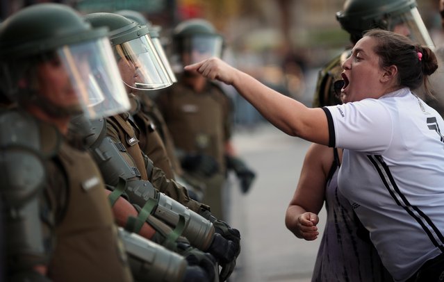A woman argues with a riot policeman during a protest against Chile's government in Santiago, Chile on December 15, 2019. (Photo by Ricardo Moraes/Reuters)