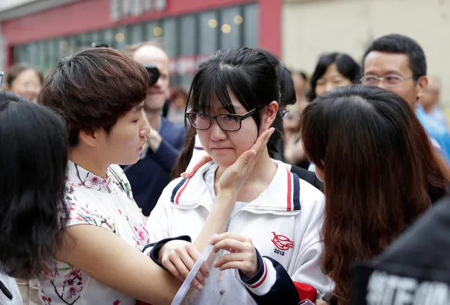 Teachers comfort a student before she walks into Chen Jinglun High School for the first part of China's annual national college entrance exam, in Beijing, China, June 7, 2016. (Photo by Jason Lee/Reuters)