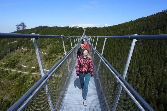 Visitors cross a suspension bridge for the pedestrians that is the longest such construction in the world shortly after its official opening at a mountain resort in Dolni Morava, Czech Republic, Friday, May 13, 2022. The 721-meter (2,365 feet) long bridge is built at the altitude of more than 1,100 meters above the sea level. It connects two ridges of the mountains up to 95 meters above a valley between them. (Photo by Petr David Josek/AP Photo)