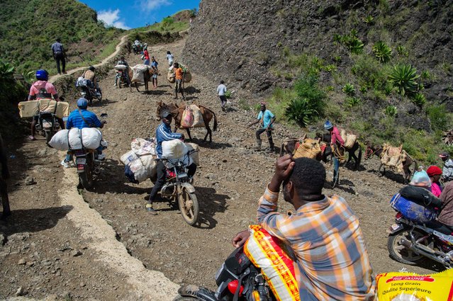 This photo taken on August 30, 2024 shows vendors passing with their goods on a rocky road taken by people attempting to avoid gangs as they leave or return to Port-au-Prince, Haiti. This road is increasingly frequented by passengers fleeing gang violence on National Route 2, linking Port-au-Prince to four other departments. The perilous journey on a rocky, cliff-lined road takes nearly seven hours for a journey that would normally take hours. About 580,000 Haitians have fled their homes due to gang violence, a 60 percent spike just since March, the UN International Organization for Migration reported June 18, 2024. (Photo by Clarens Siffroy/AFP Photo)