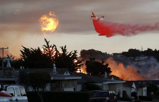 In this September 9, 2010, file photo, a massive fire following a pipeline explosion roars through a mostly residential neighborhood in San Bruno, Calif. One of the country's largest utility companies is set to face a jury in a criminal trial accusing it of misleading investigators in the wake of a deadly pipeline explosion in the San Francisco Bay Area. The September 2010 blast of a Pacific Gas & Electric Co. natural gas pipeline sent a giant plume of fire into the air in a neighborhood in San Bruno, killing eight people and destroying 38 homes. Opening arguments in the trial began Thursday, June 16, 2016. (Photo by Jeff Chiu/AP Photo)