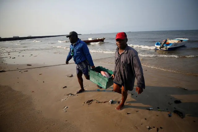 Fisherman carry their catch to sell on the beach in Libreville, Gabon, February 3, 2017. (Photo by Mike Hutchings/Reuters)