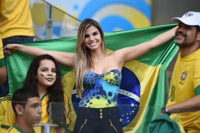 Fans of Brazil pose before the semi-final football match between Brazil and Germany at The Mineirao Stadium in Belo Horizonte during the 2014 FIFA World Cup on July 8, 2014. (Photo by Patrik Stollarz/AFP Photo)