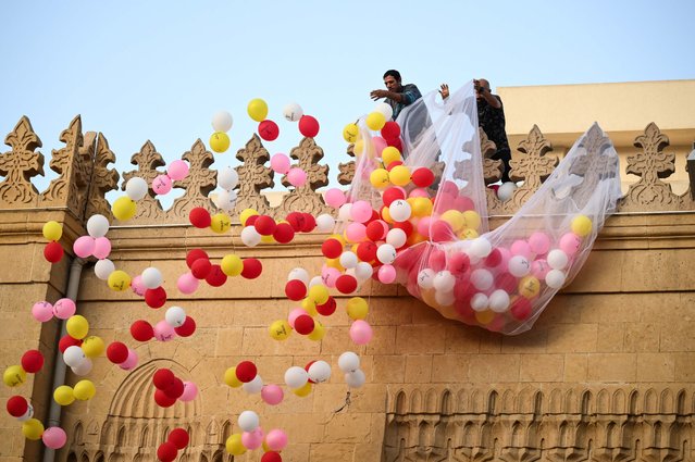 Two men throw ballons during an Eid Al-Adha prayer service at Al Sayida Zinab mosque in Cairo, Egypt, 16 June 2024. Eid al-Adha is the holiest of the two Muslims holidays celebrated each year, it marks the yearly Muslim pilgrimage (Hajj) to visit Mecca, the holiest place in Islam. Muslims slaughter a sacrificial animal and split the meat into three parts, one for the family, one for friends and relatives, and one for the poor and needy. (Photo by Mohamed Hossam/EPA)