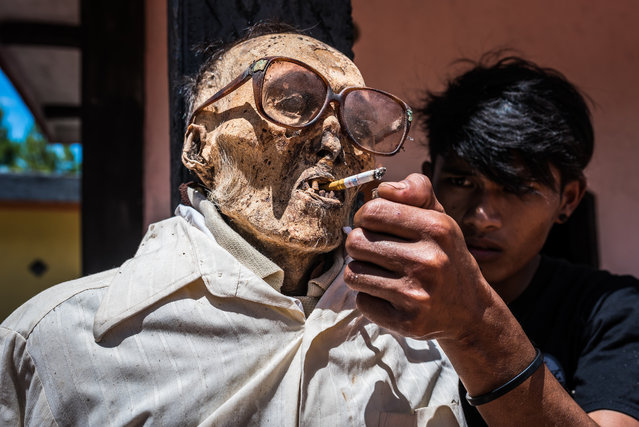 Undated picture shows Sam lighting the cigarette for the corpse of hid grandfather Songa who died in 1977 in Tana Toraja, Indonesia. Funeral ceremonies are incredibly important to the Tarajans and are often held weeks, months, or even years after the death of a person to give the family of the deceased time to raise enough money for expenses. Many families go deeply into debt in order to hold an extravagant funeral ceremony. (Photo by Claudio Sieber/Barcroft Media)