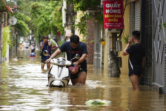 People wade in a flooded street in the aftermath of Typhoon Yagi, in Hanoi, Vietnam on Thursday, September 12, 2024. (Phoot by Hau Dinh/AP Photo)