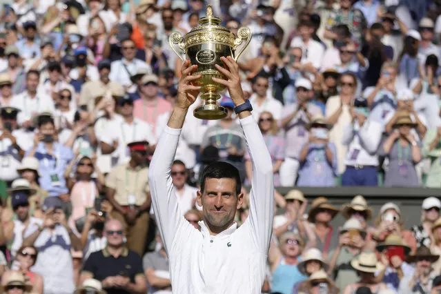 Serbia's Novak Djokovic celebrates beating Australia's Nick Kyrgios in the final of the men's singles on day fourteen of the Wimbledon tennis championships in London, Sunday, July 10, 2022. (Photo by Kirsty Wigglesworth/AP Photo)