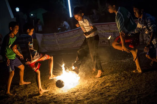 Children play a game of fire football, known as “bola api”, a coconut is soaked in kerosene and set on fire during celebrations of Indonesia's National Independence Day on August 15, 2015 in Yogyakarta, Indonesia. (Photo by Ulet Ifansasti/Getty Images)
