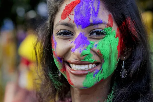 An Indian girl with her face smeared with colored powder smiles during Holi festival, in Kolkata, India, Monday, March 9, 2020. Holi, the Hindu festival of colors, also heralds the coming of spring. (Photo by Bikas Das/AP Photo)