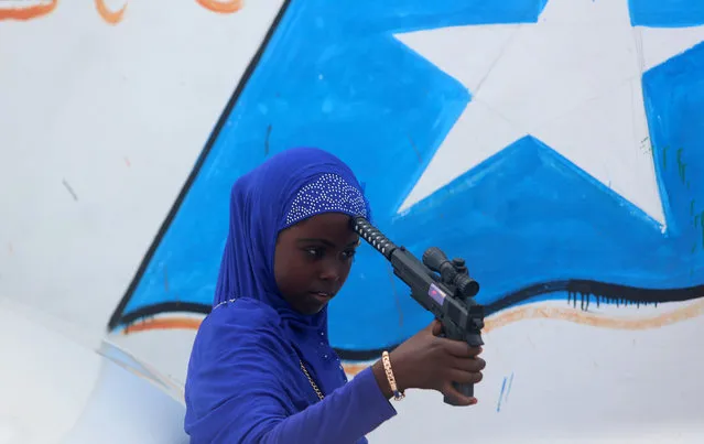 A Somali girl plays with a toy gun after attending Eid al-Fitr prayers to mark the end of the fasting month of Ramadan in Somalia's capital Mogadishu, July 6, 2016. (Photo by Feisal Omar/Reuters)