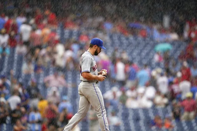 New York Mets pitcher Nate Fisher walks to the mound in a rain storm during the sixth inning of a baseball game against the Philadelphia Phillies, Sunday, August 21, 2022, in Philadelphia. (Photo by Matt Slocum/AP Photo)