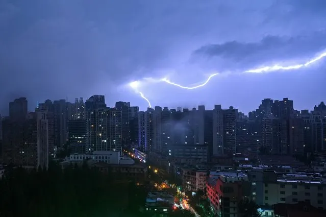 Lightning strikes during a thunderstorm over Shanghai on July 11, 2022. (Photo by Hector Retamal/AFP Photo)