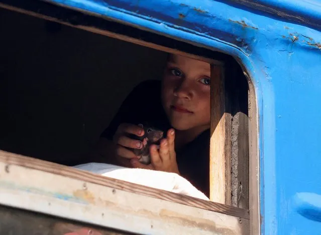 A youngster looks out the window of a train to Dnipro and Lviv during an evacuation effort from war-affected areas of eastern Ukraine, amid Russia's invasion of the country, in Pokrovsk, Donetsk region, Ukraine on August 19, 2022. (Photo by Ammar Awad/Reuters)