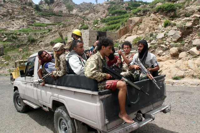Pro-government fighters ride on the back of a patrol truck in a village taken by pro-government forces from the Iran-allied Houthi militia, in the al-Sarari area of Taiz province, Yemen July 28, 2016. (Photo by Anees Mahyoub/Reuters)