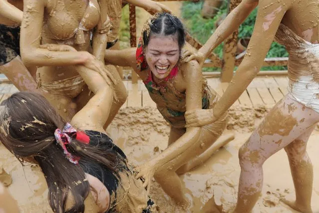 This photo taken on September 10, 2014 shows women playing with mud in a tourist area of Zhangjiajie, central China's Hunan province. The Asia-Pacific region, led by China, will be the main force driving world tourism in the next 10 years, according to a consultancy survey forecast. (Photo by AFP Photo)