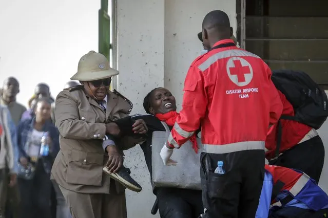 Medics treat an injured woman after people broke through barriers causing a stampede, as they tried to force their way into Kasarani stadium, where the inauguration of Kenya's new president William Ruto is due to take place later today, in Nairobi, Kenya Tuesday, September 13, 2022. (Photo by Brian Inganga/AP Photo)