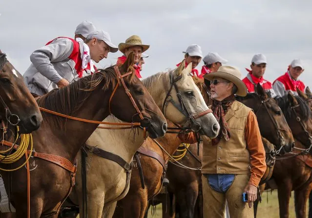 Steven Bond (R) from Texas, U.S. talks to participants before the start of the Russian Rodeo in the village of Kotliakovo, Bryansk region, southeast of Moscow, Russia, September 12, 2015. (Photo by Maxim Shemetov/Reuters)