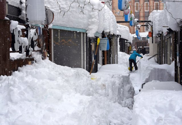 A man digs snow following heavy snowfall in Obihiro, Hokkaido, northern Japan, 04 February 2025. On 05 February 2025, the coldest air of the winter persisted over the Japanese archipelago, bringing heavy snowfall to Hokkaido and areas along the Sea of Japan coast. The cold front is expected to continue for several days, and the Japan Meteorological Agency (JMA) has issued warnings about heavy snow and blizzards, which already led to school closures and transportation disruptions. (Photo by JIJI Press/EPA/EFE)