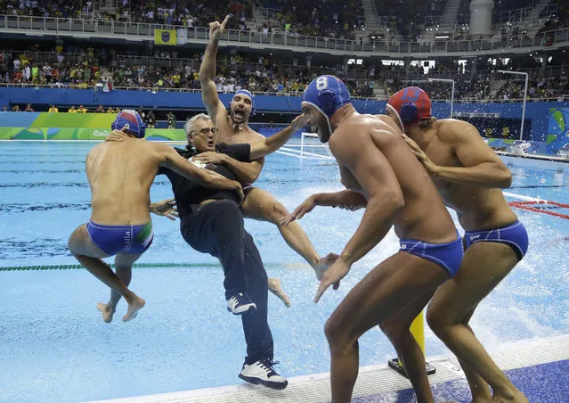 Members of Italy team jump into water with their coach Alessandro Campagna as they celebrate their victory during men's bronze medal water polo match against Montenegro at the 2016 Summer Olympics in Rio de Janeiro, Brazil, Saturday, August 20, 2016. (Photo by Sergei Grits/AP Photo)