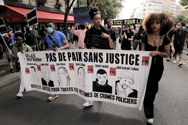 People march holding a banner that reads “No country without justice – Truth and justice for all the victims of police crimes” during a protest in memory of Lamine Dieng, a 25-year-old Franco-Senegalese who died in a police van after being arrested in 2007, in Paris, Saturday, June 20, 2020. Multiple protests are taking place in France on Saturday against police brutality and racial injustice, amid weeks of global anger unleashed by George Floyd's death in the US. (Photo by Christophe Ena/AP Photo)