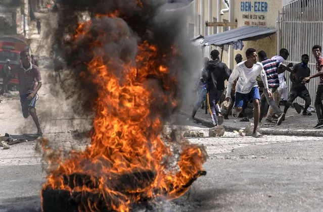 Protesters throw stones at police during a protest over the death of a journalist Romelo Vilsaint, in Port-au-Prince, Haiti, Sunday, October 30, 2022. (Photo by Ramon Espinosa/AP Photo)