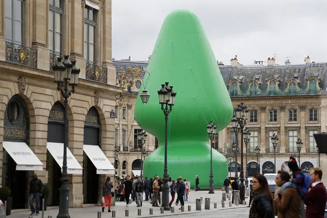 People walk near Paul McCarthy's “Tree” creation which is displayed on the  Place Vendome in Paris October 16, 2014. (Photo by Charles Platiau/Reuters)