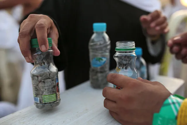 Muslim pilgrims collect stones in bottles as they make their way to cast stones at a pillar symbolizing the stoning of Satan, in a ritual called “Jamarat”, the last rite of the annual hajj, on the first day of Eid al-Adha, in Mina near the holy city of Mecca, Saudi Arabia, Thursday, September 24, 2015. (Photo by Mosa'ab Elshamy/AP Photo)