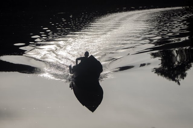 A youth navigates a motor boat on the Rio Caxiuana near Brazil's Ferreira Penna Scientific Station, in Para state, March 21, 2025. (Photo by Jorge Saenz/AP Photo)