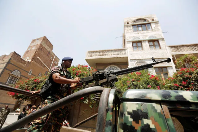 A soldier holds a machine gun mounted on a police truck outside Yemen's parliament during a session held by the parliament for the first time since a civil war began almost two years ago, in Sanaa, Yemen August 13, 2016. (Photo by Khaled Abdullah/Reuters)