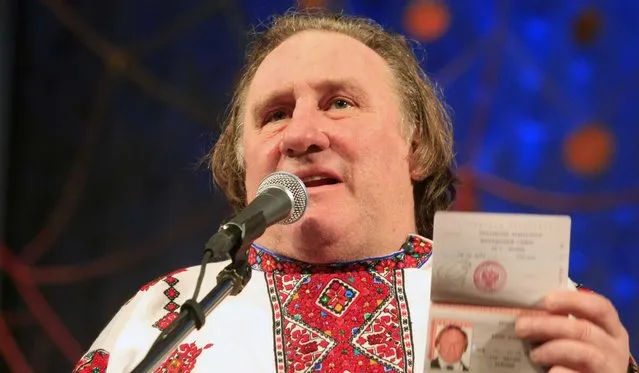 Actor Gerard Depardieu poses with his new Russian passport on a theatre stage, wearing a traditional folk outfit, after he arrived in the city of Saransk, 700 kilometres east of Moscow, January 7, 2013. (Photo by Mordovmedia.ru/Associated Press)