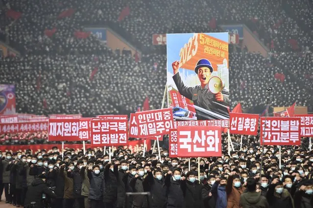 In this photo taken on January 5, 2023, people hold placards including one (top) that translates as “2023 – Key year of five-year plan implementation” during a rally to vow to carry through the decisions of the 6th Plenary Meeting of the 8th Central Committee of the Workers' Party of Korea (WPK) at the Mayday Stadium in Pyongyang. (Photo by Kim Won Jin/AFP Photo)